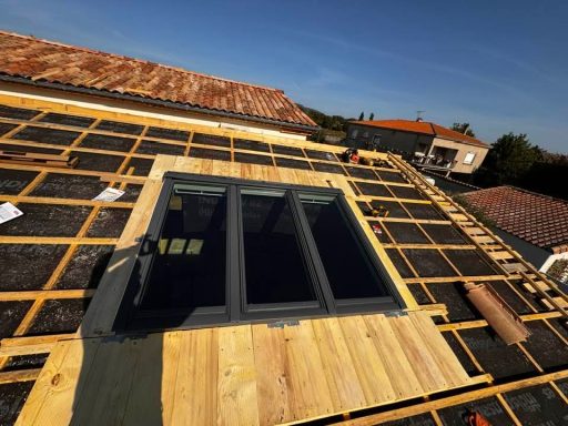 Toiture en cours de réalisation avec pose du lattage et du contre-lattage, grand Velux et création d’un chevêtre autour de la fenêtre de toi