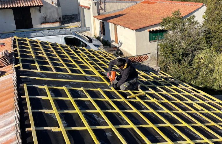 Couvreur réalisant le lattage et le contre-lattage sur un écran sous-toiture lors de travaux de couverture.