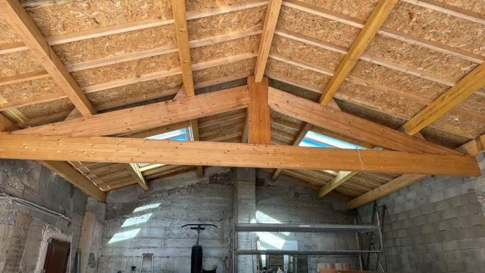 Charpente traditionnelle en bois vue de l’intérieur de la toiture.