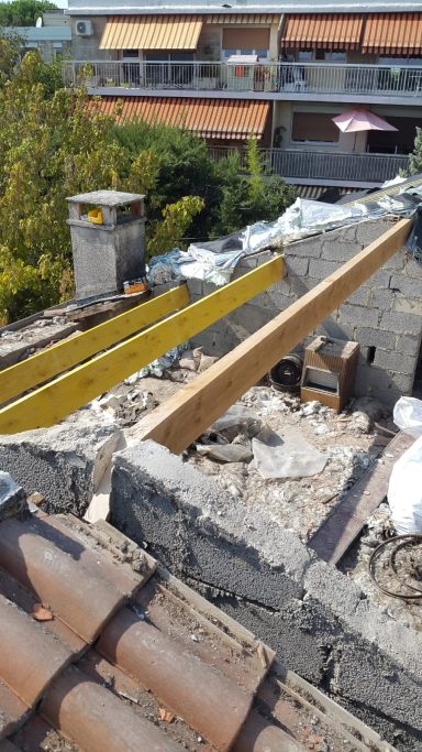 Toiture déposée avec trois poutres en bois nouvellement posées pour la réalisation de la charpente.